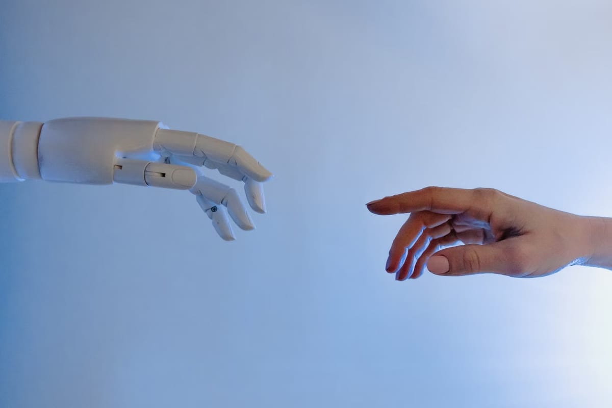 Uma mão de robô e uma mão humana se aproximando sobre fundo azul claro