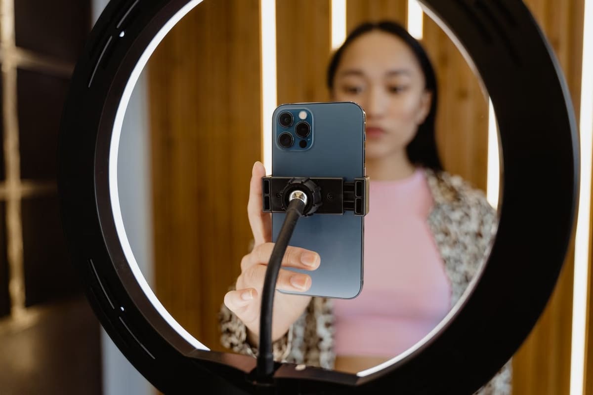 Mulher gravando vídeo com o celular preso a um ring light